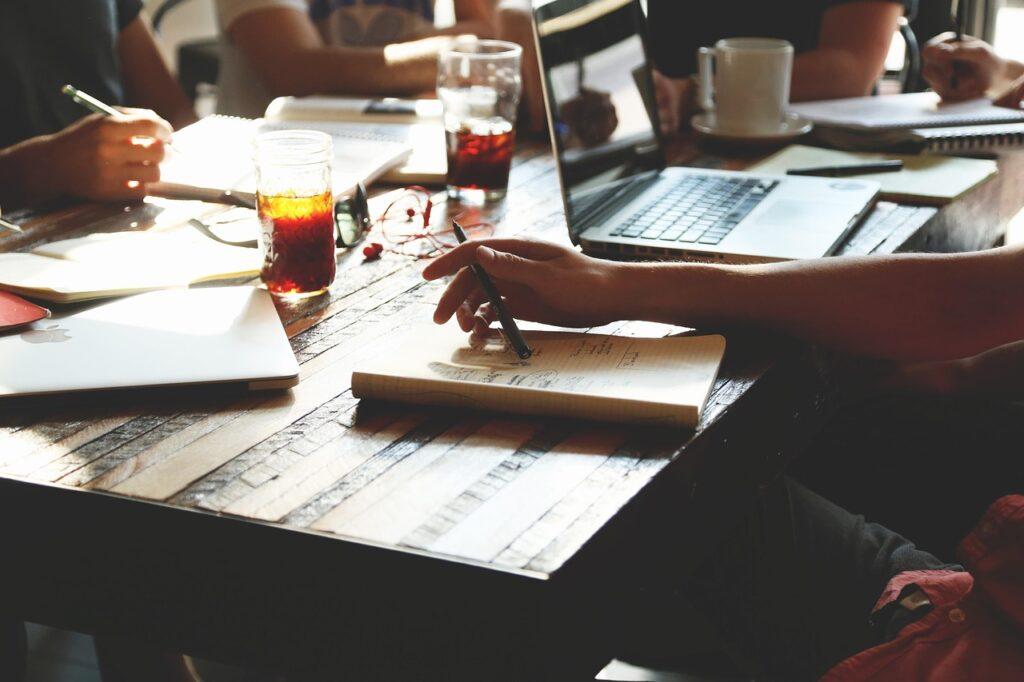 Editing Content on a laptop and in a journal.
