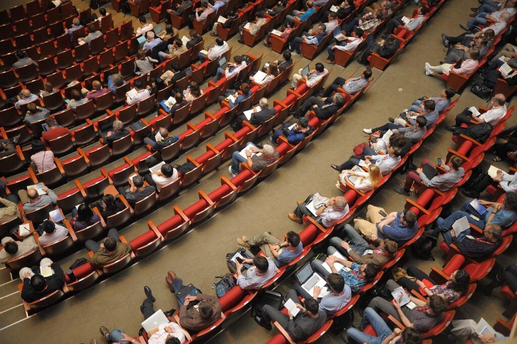 Know your audience - an overhead shot of an auditorium with 50 percent of the seats filled.
